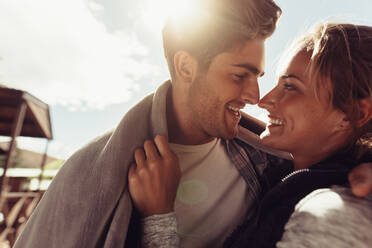 Nahaufnahme eines fröhlichen Mannes und einer Frau, die sich verliebt anschauen und lächeln. Romantisches Paar im Winterurlaub. - JLPSF24606