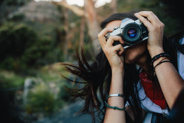 Frau im Freien, die mit ihrer Kamera Fotos macht. Weibliche Reisende, die Erinnerungen an ihre Reise macht. - JLPSF24780