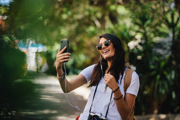 Schöne weibliche Reisende nimmt Selfie mit ihrem Smartphone. Frau im Urlaub sprechen Selbstporträt auf ihrem Mobiltelefon. - JLPSF24783