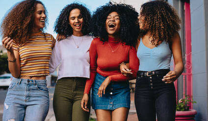 Group of female friends walking together outdoors in the city. Young women hanging out in the city. - JLPSF24840