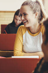 Lächelndes Mädchen im Klassenzimmer. Lächelnde Studentin während einer Vorlesung in der High School. - JLPSF24891