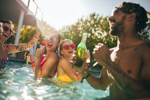 Gruppe von glücklichen Freunden am Pool Party mit Bieren. Männer und Frauen Menschen lachen und haben Spaß im Schwimmbad. - JLPSF25434