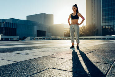 Young female standing outdoors before demonstrating trick techniques. Fit young woman getting ready to practice tricking. - JLPSF25526