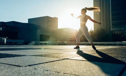 Junge Sportlerin beim Tricking-Training im Freien in der Stadt. Fitte junge Frau beim Tricking-Training in städtischer Umgebung. - JLPSF25528