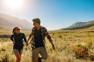 Junger Mann und Frau wandern an einem sonnigen Tag. Schönes Paar auf Wanderweg im Naturschutzgebiet. - JLPSF25582