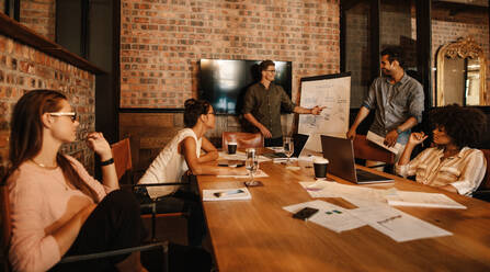 Gruppe junger Geschäftsleute bei einer Besprechung. Unterschiedliche Gruppen von Mitarbeitern bei einer Besprechung im Büro. - JLPSF25631