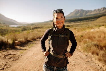 Schöne Frau beim Wandern mit Rucksack auf dem Lande. Asiatische Wanderin auf Wanderweg in Naturschutzgebiet. - JLPSF25700