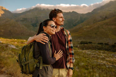 Shot of happy young couple on hiking trip in nature admiring the view. young man and woman on hiking trip standing together looking at the view. - JLPSF25710