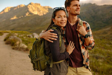 Portrait of young asian woman with her boyfriend. Couple hiking in nature, standing together on hiking trail. - JLPSF25715