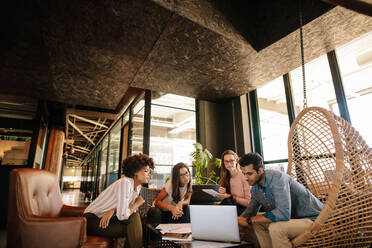 Creative business team using laptop during meeting. Young multi ethnic businesspeople meeting in modern office. - JLPSF25789