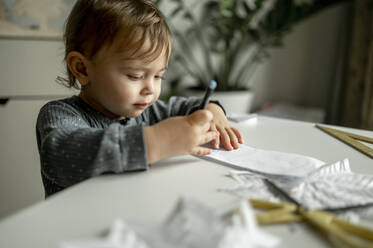 Toddler with colored pencil drawing on paper at home - ANAF00378