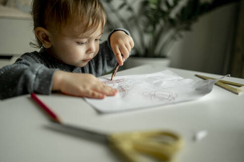 Boy drawing with pencil on paper at home - ANAF00385