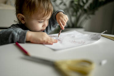Junge, der zu Hause mit Buntstiften auf Papier zeichnet - ANAF00386