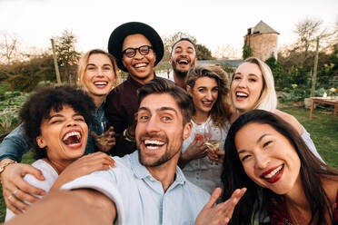 Freunde, die draußen chillen, ein Gruppen-Selfie machen und lächeln. Lachende junge Leute, die zusammen im Freien stehen und ein Selfie machen. - JLPSF25822