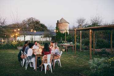 Eine Gruppe von Männern und Frauen, die im Freien in einem Restaurant feiern. - JLPSF25824