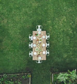 Luftaufnahme eines gedeckten Tisches in einem Gartenrestaurant. Der Tisch ist bereit für eine Mahlzeit im Freien. - JLPSF25935