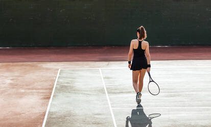 Rückansicht einer Tennisspielerin auf dem Tennisplatz. Sportliche Frau spielt auf dem Tennisplatz. - JLPSF25951
