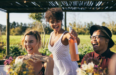 Happy friends having fun outdoors during a party. Young people enjoying time together at garden restaurant. - JLPSF25973