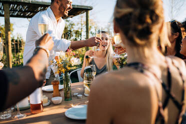 Eine Gruppe von Freunden stößt auf einer Party mit Getränken an. Junge Leute hängen in einem Restaurant ab und trinken etwas. - JLPSF25977