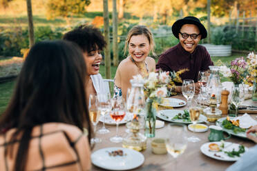 Eine Gruppe von Freunden genießt eine Outdoor-Party im heimischen Garten. Millennials genießen eine sommerliche Mahlzeit im Restaurant. - JLPSF25988