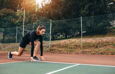 Porträt einer Sportlerin beim Stretching im Freien. Schöne Frau beim Training auf dem Tennisplatz. - JLPSF26036