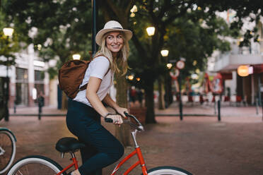 Attractive young woman cycling in the city. Female riding bicycle. - JLPSF26143