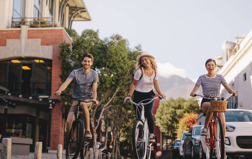 Eine Gruppe von Freunden fährt mit dem Fahrrad im Freien, ein Mann und eine Frau radeln in der Stadt. - JLPSF26165