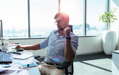 Young entrepreneur looking at the computer screen with concentration at his desk. Businessman in pensive mood sitting at his desk. - JLPSF26202