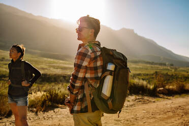 Hübscher junger Mann auf einer Wanderung mit Frau im Hintergrund. Paar auf Wanderung in der Natur. - JLPSF26282