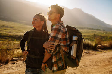 Junger Mann und Frau wandern an einem sonnigen Tag mit Blick auf eine Aussicht. Schönes Paar auf Wanderweg im Naturschutzgebiet. - JLPSF26283