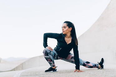 Gesundheit und Fitness. Fitte junge Frau beim Stretching-Workout. Fitnessmodell beim morgendlichen Training im Freien. - JLPSF26364