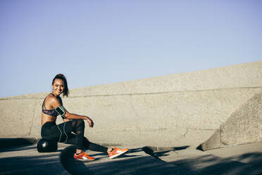Gesunde Lebensweise: Junge Frau, die sich auf einem Fitnessball im Freien ausruht. Frau, die sich nach dem Sport im Freien ausruht. - JLPSF26374
