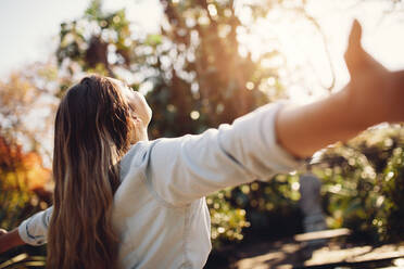 Young woman spreading hands with joy and inspiration outdoors. Female feeling free with arms wide open. - JLPSF26546