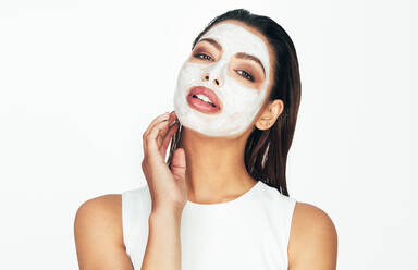 Nahaufnahme einer Frau mit einer kosmetischen Gesichtsmaske, die auf ihr Gesicht aufgetragen wurde. - JLPSF26638
