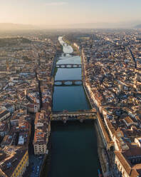 Luftaufnahme der Skyline von Florenz entlang des Flusses Arno bei Sonnenuntergang mit der Ponte Vecchio-Brücke im Vordergrund, Florenz, Toskana, Italien. - AAEF16574