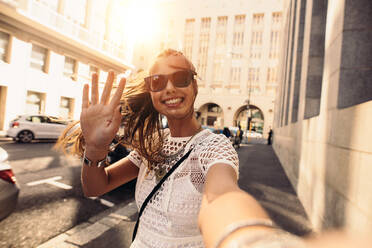 Tourist posing for a selfie in a street. Vlogger recording content for her travel vlog. - JLPSF26955