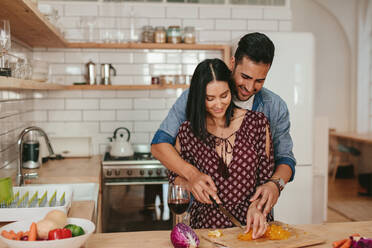 Shot of romantic young couple chopping vegetables together in kitchen. Young man and woman cooking food together at home. - JLPSF27067