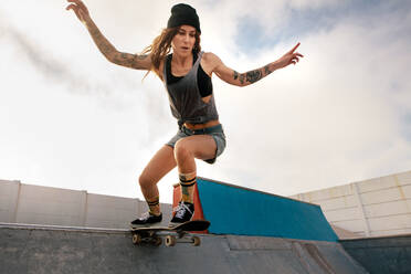 Coole junge Frau auf dem Skateboard im Skatepark. Weibliche Skaterin fährt auf dem Skateboard. - JLPSF27139