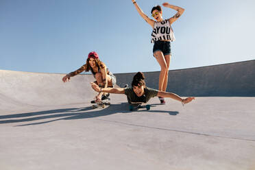 Eine Gruppe von Frauen spielt mit Skateboards im Freien und genießt das Skateboardfahren im Skatepark. - JLPSF27157