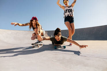 Eine Gruppe von Mädchen fährt Skateboard und hat Spaß im Skatepark. - JLPSF27158