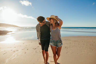 Loving young couple enjoying a day on beach. Beautiful couple walking on the seashore on a summer day. - JLPSF27264