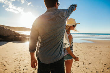 Aufnahme eines romantischen jungen Paares, das an einem Sommertag am Strand tanzt. Junger Mann und Frau tanzen am Meer. - JLPSF27268