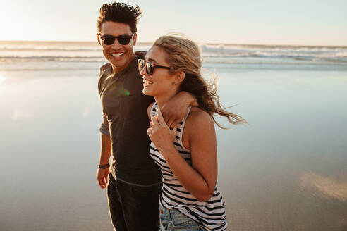 Porträt eines romantischen jungen Paares, das am Meer spazieren geht. Mann und Frau im Sommerurlaub am Strand. - JLPSF27286