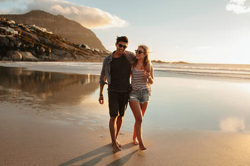 Ganzkörperporträt eines romantischen jungen Paares, das am Meer spazieren geht. Mann und Frau genießen einen Tag am Strand. - JLPSF27289