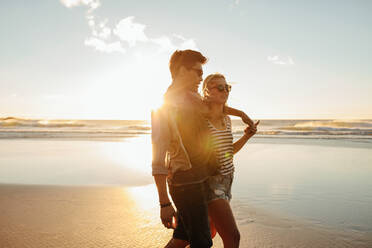 Outdoor shot of beautiful young couple together on seashore. Young man and woman having summer holidays on beach. - JLPSF27290