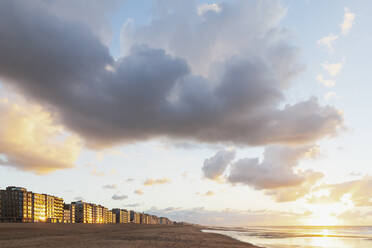 Belgien, Westflandern, Wolken über Wohnhäusern am Strand bei Sonnenuntergang - GWF07629