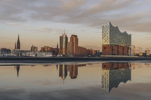 Germany, Hamburg, Elbphilharmonie reflecting in Elbe river at dusk - KEBF02446