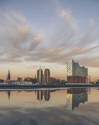 Deutschland, Hamburg, Elbphilharmonie spiegelt sich in der Elbe in der Abenddämmerung - KEBF02447