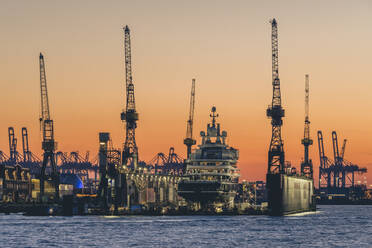Germany, Hamburg, Harbor cranes at moody dawn - KEBF02457