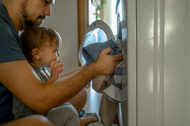 Father with son doing household chores at home - ANAF00424